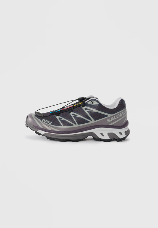 Scarpa da trail running viola con tomaia in rete, dettagli riflettenti e sistema di allacciatura rapida. Presenta una suola in gomma durevole e un'intersuola ammortizzata.