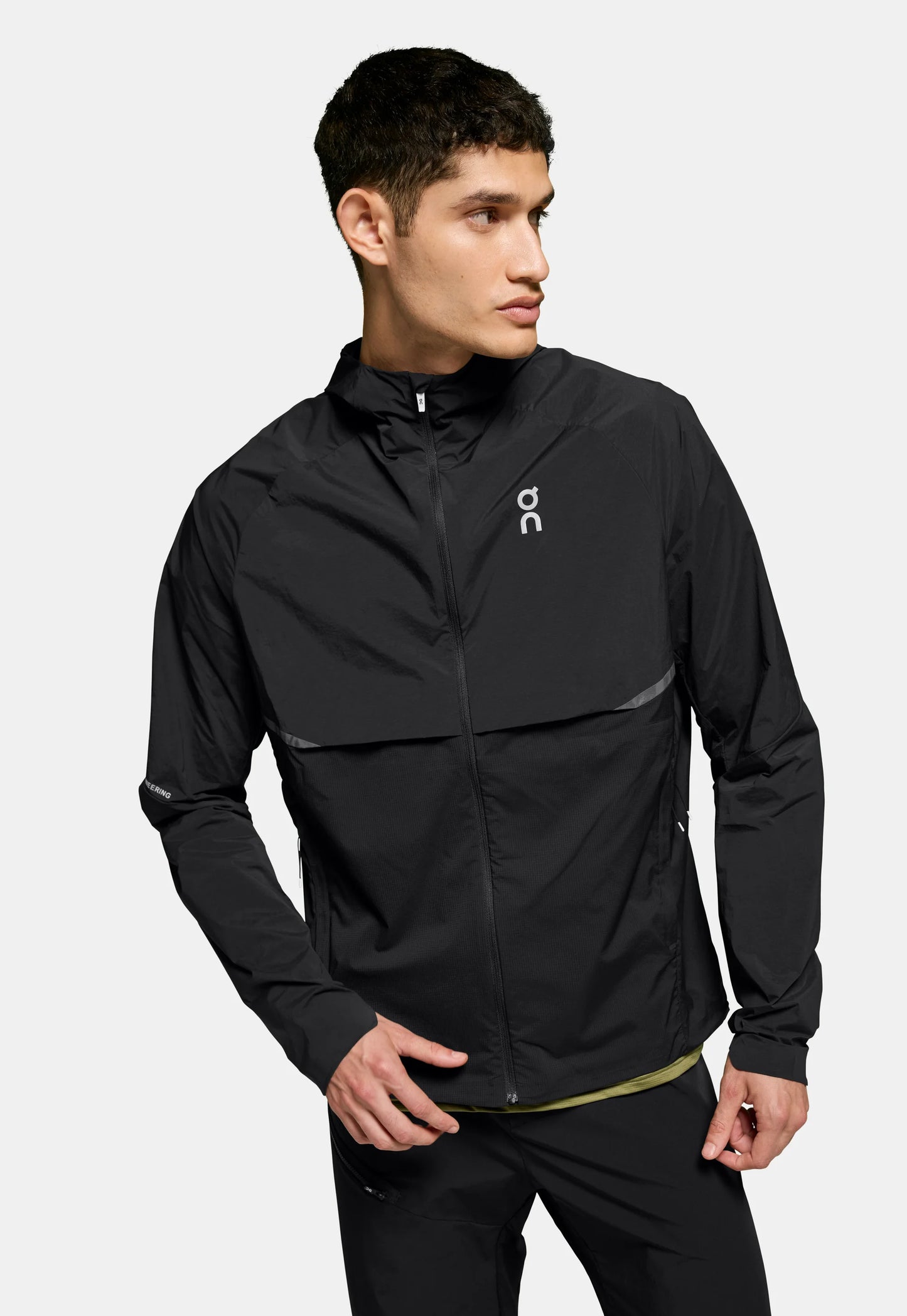 Giacca leggera nera con zip frontale, maniche lunghe e dettagli riflettenti. Presenta un colletto alto e un logo tono su tono sul petto.