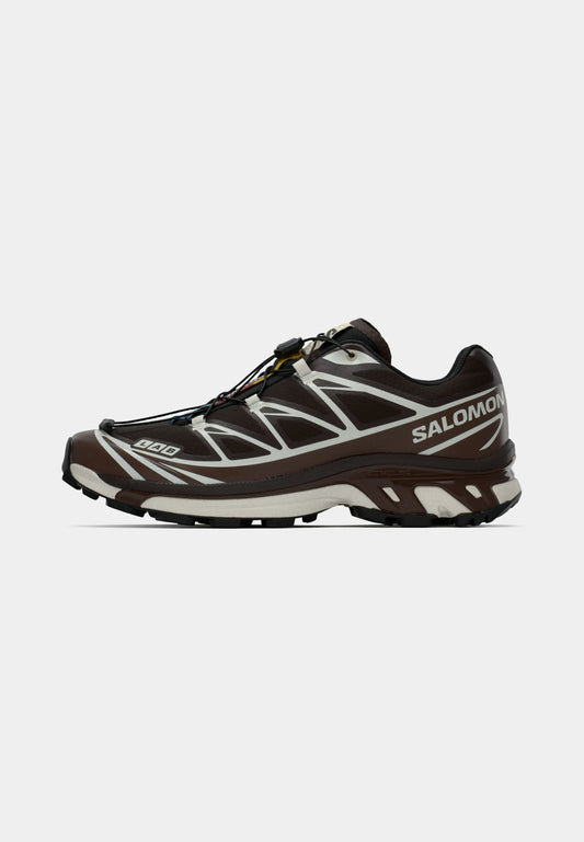 Scarpa da corsa Salomon di colore marrone scuro con accenti riflettenti. Presenta un design curvo distintivo, tomaia testurizzata e suola in gomma leggera.