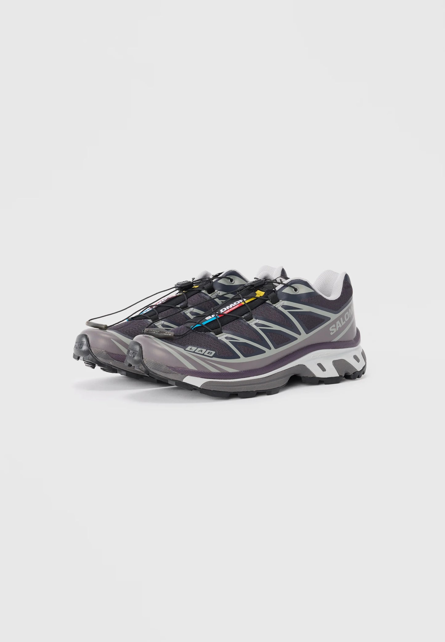Scarpe leggere da esterno realizzate in rete e gomma. Grigio scuro con dettagli riflettenti, sistema di allacciamento rapido e suole texturizzate per una migliore aderenza.