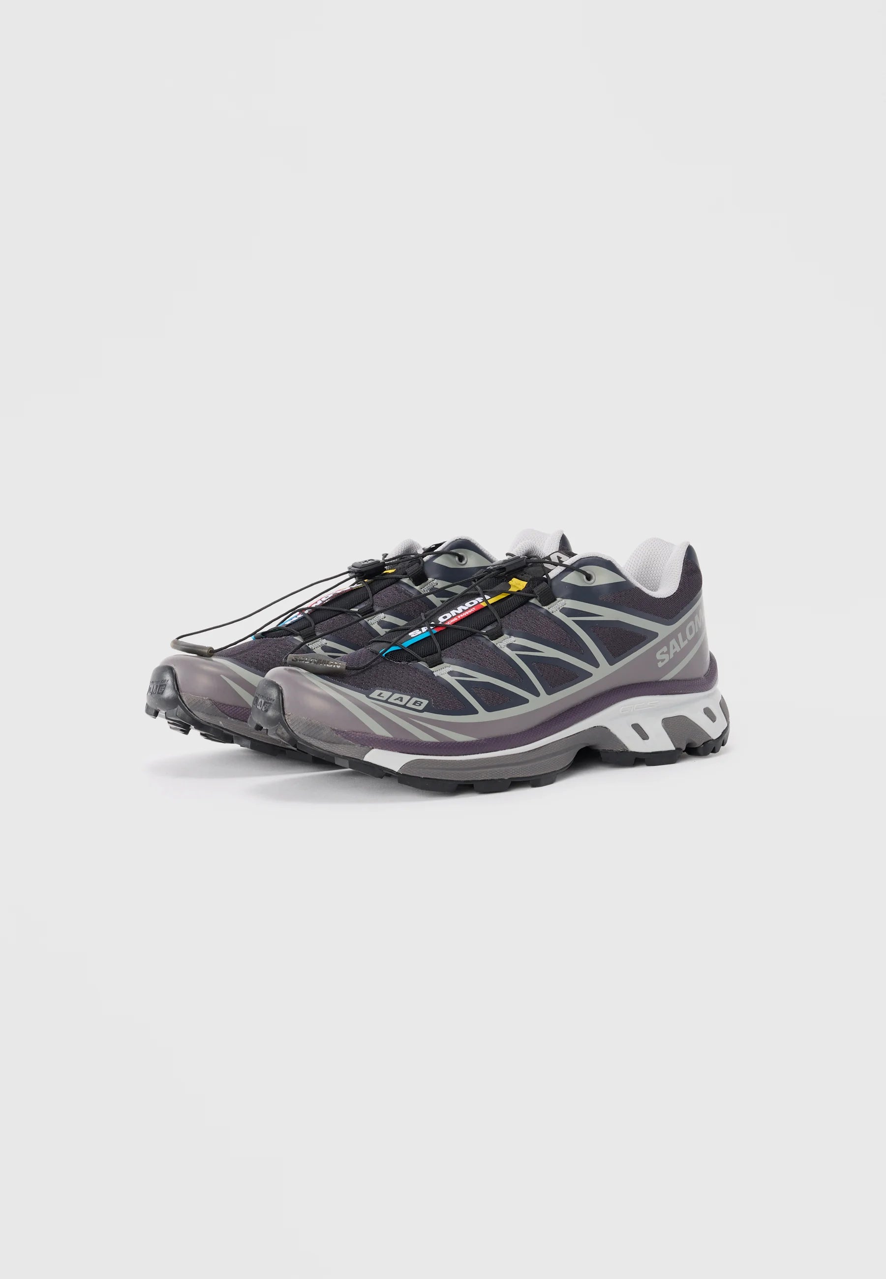 Scarpe leggere da esterno realizzate in rete e gomma. Grigio scuro con dettagli riflettenti, sistema di allacciamento rapido e suole texturizzate per una migliore aderenza.