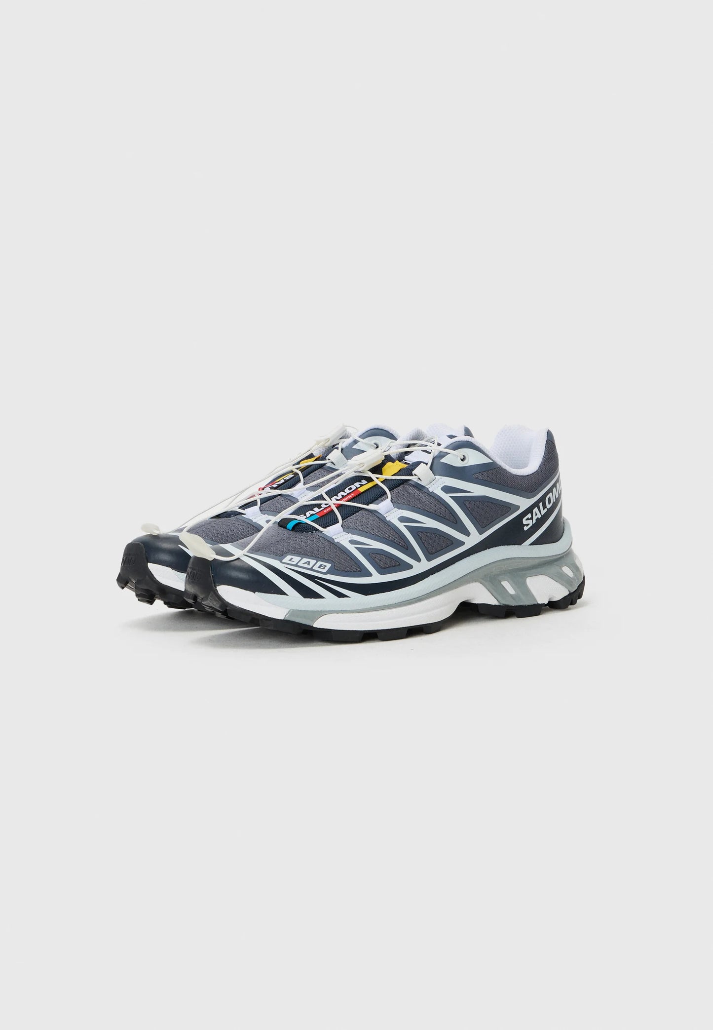 Scarpe sportive blu navy con tomaia in rete, dettagli bianchi e suola in gomma nera. Presentano lacci elasticizzati e un dettaglio logo multicolore.
