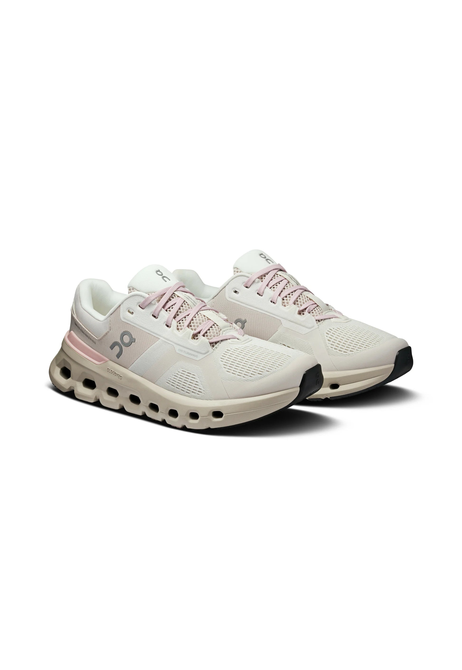 Un paio di scarpe da corsa beige chiaro e rosa con tomaia in rete, suole ammortizzate con ritagli a forma di quadrato vuoto e logo del marchio sui lati.