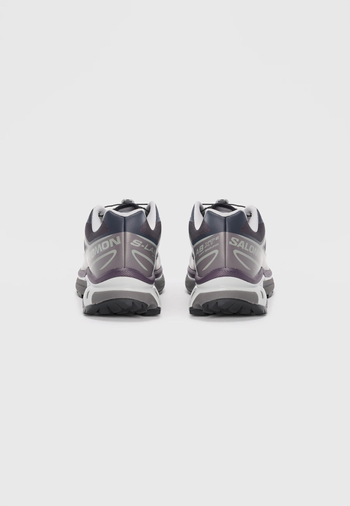 Scarpe da trail running nere e viola con accenti grigi, dotate di una suola testurizzata e di un sistema di laccio sicuro. Branding sulla parte laterale.