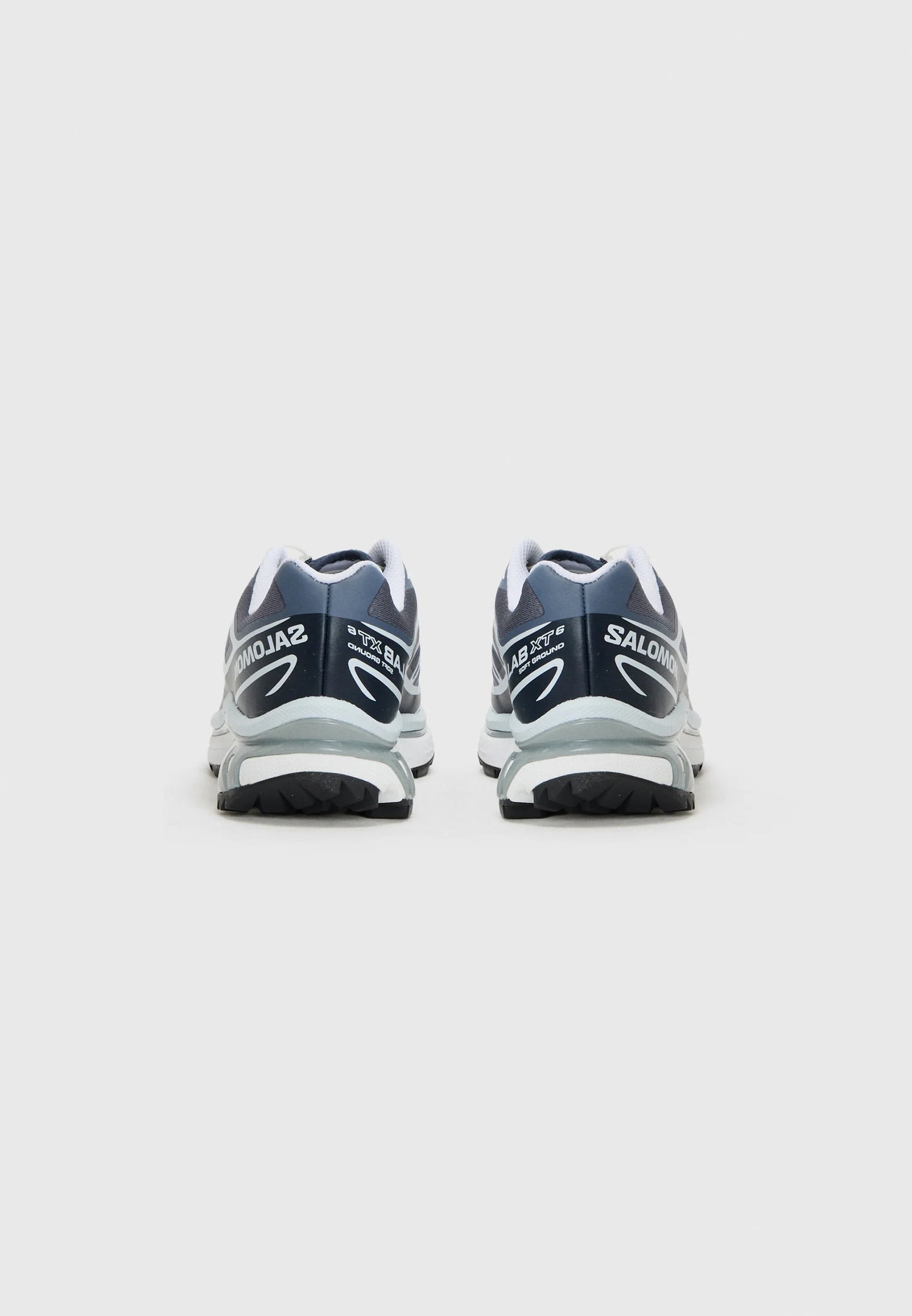 Scarpe da corsa blu scuro con accenti bianchi, dotate di un colletto imbottito e suola testurizzata. Marchio visibile sul tallone e sul lato.
