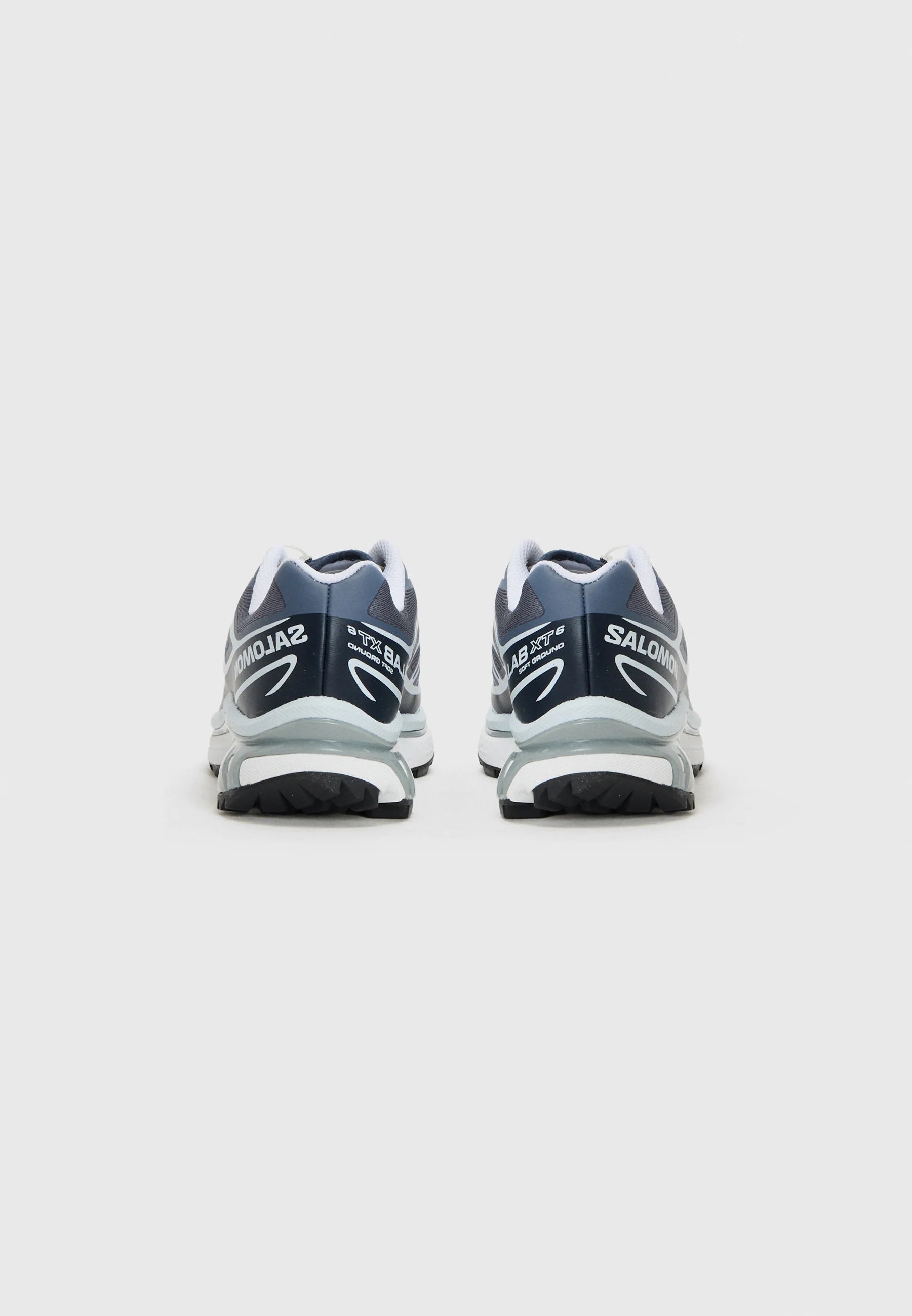 Scarpe da corsa blu scuro con accenti bianchi, dotate di un colletto imbottito e suola testurizzata. Marchio visibile sul tallone e sul lato.
