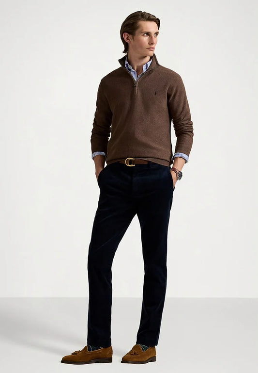 Suéter de cremallera texturizado marrón sobre una camisa a rayas azul y blanca; combinado con pantalones navy y mocasines de ante marrón con borlas.