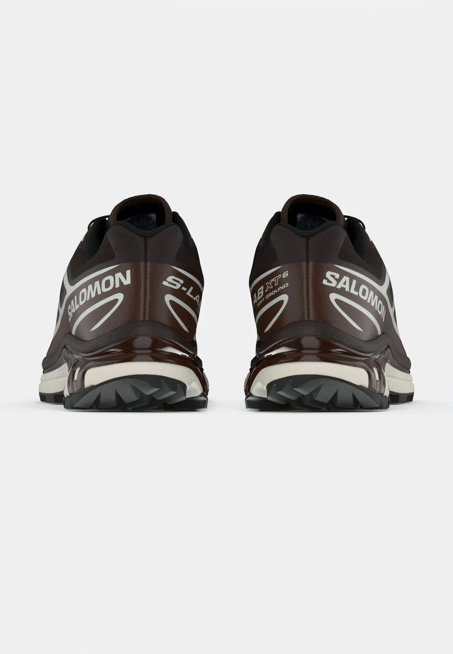 Scarpe sportive marroni con accenti neri, design elegante, materiale leggero, suole testurizzate e marchio "SALOMON" ben visibile.