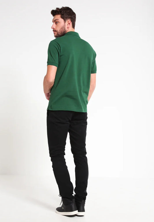 Polo verde con orlo dritto, maniche corte e colletto, abbinato a pantaloni neri e scarpe nere, visto da dietro.