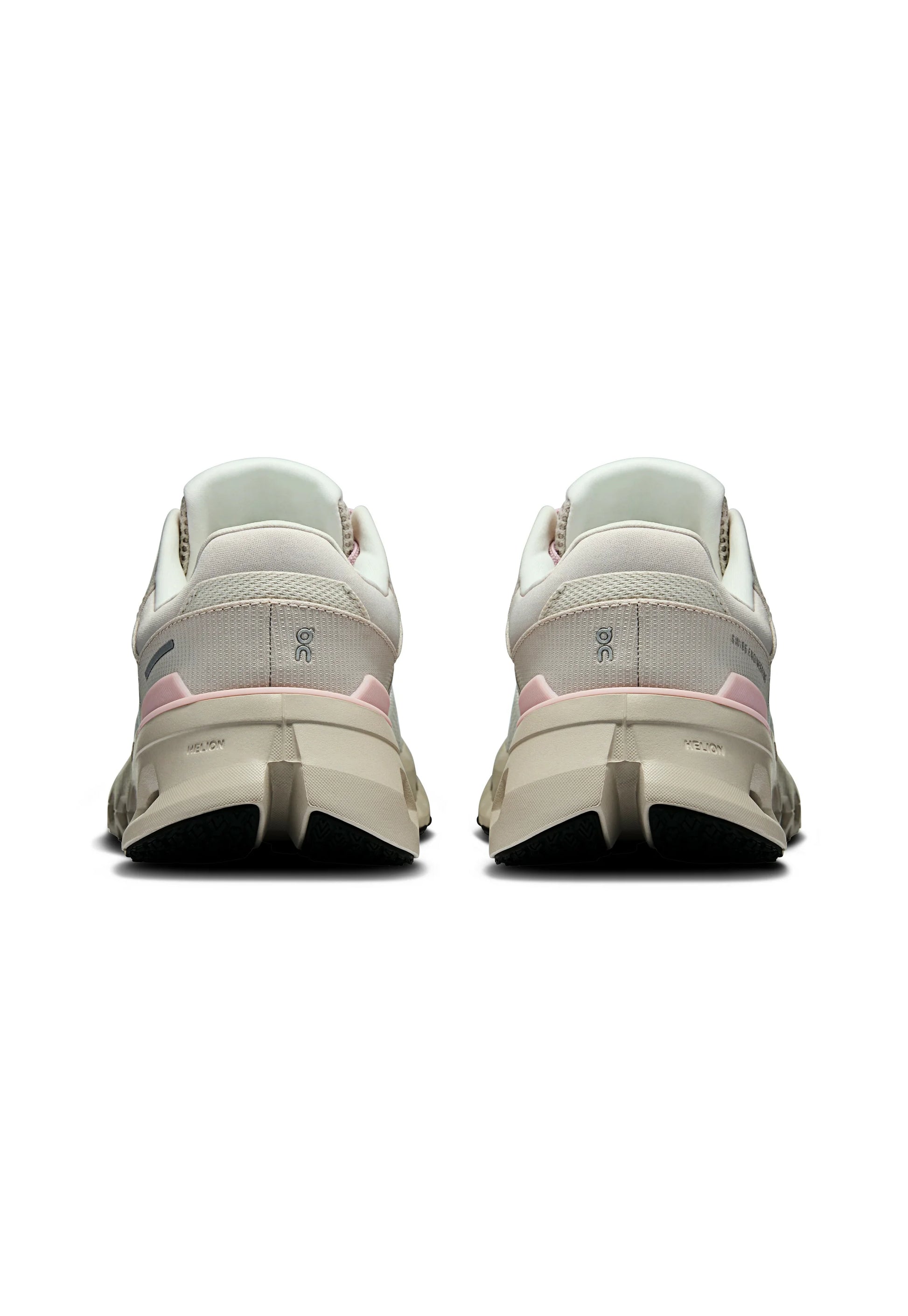 Una coppia di scarpe da ginnastica beige e rosa vista da dietro, con suole spesse e loghi del marchio ben visibili sui talloni.
