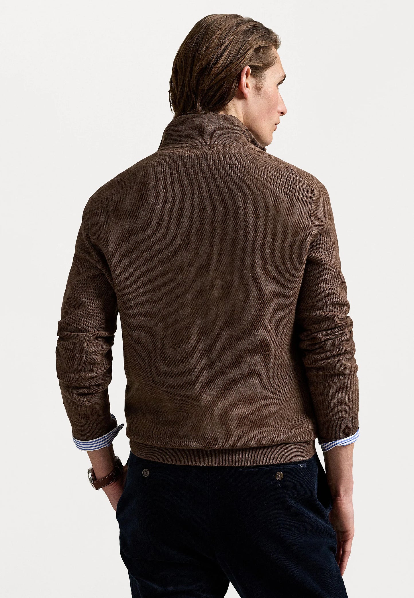 Suéter de punto marrón con cuello con cremallera, puños y dobladillo acanalados, que cuenta con un pequeño logotipo en el pecho. Material texturizado.