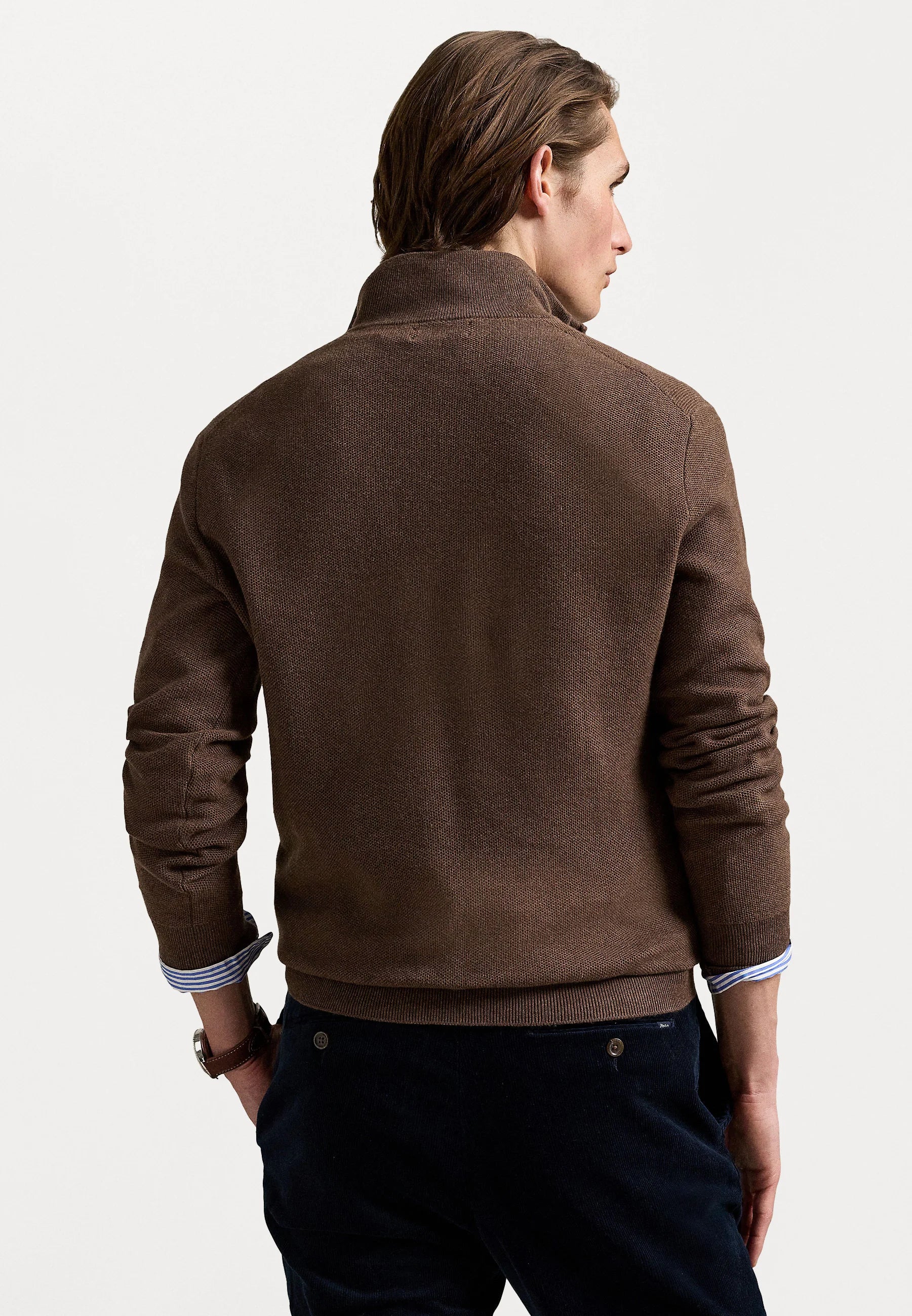 Suéter de punto marrón con cuello con cremallera, puños y dobladillo acanalados, que cuenta con un pequeño logotipo en el pecho. Material texturizado.