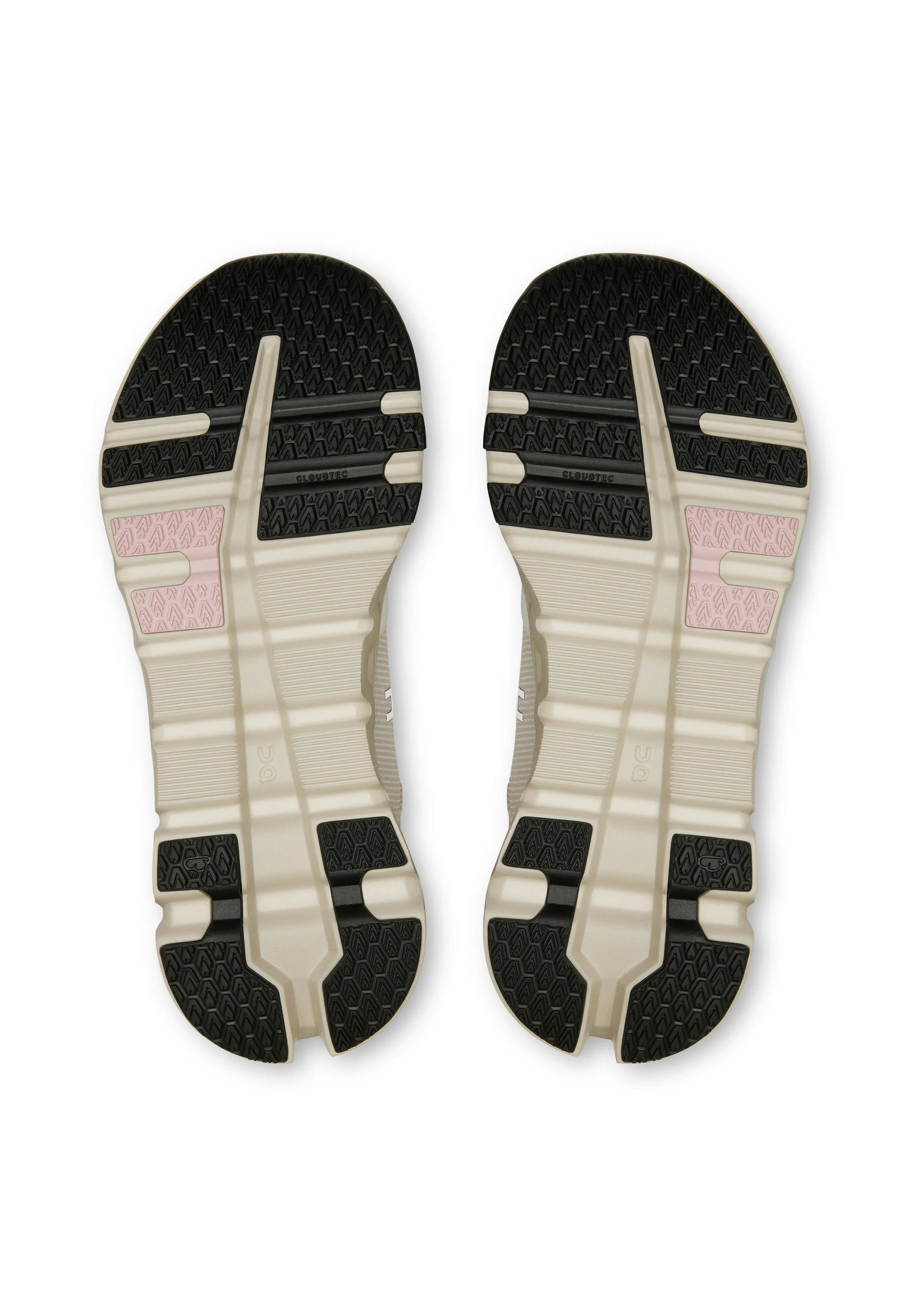 Suole delle scarpe con base beige, motivi di battistrada neri e piccole sezioni di grip rosa, mostrando un design simmetrico e il marchio "Cloudtec".